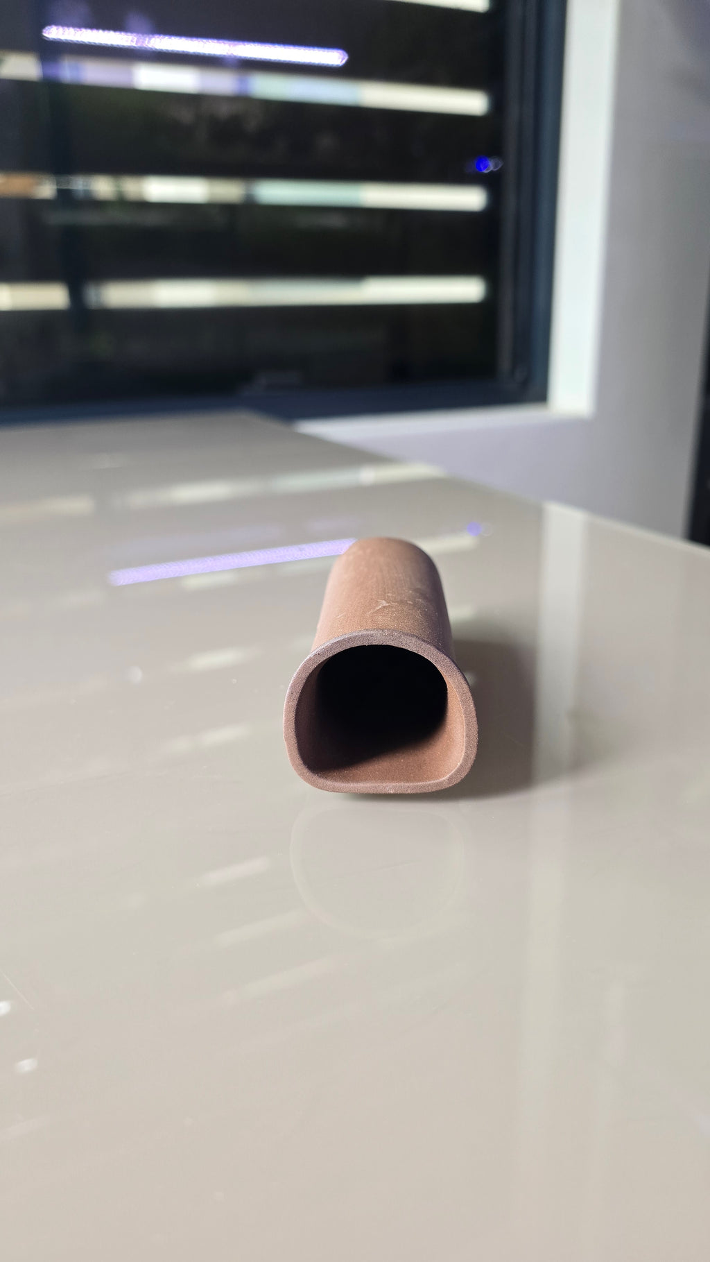 A close-up of a small, tapered ceramic cave.