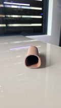 A close-up of a small, tapered ceramic cave.
