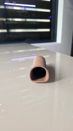 A close-up of a small, tapered ceramic cave.