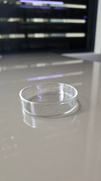A close-up of a clear, transparent circular glass dish. 