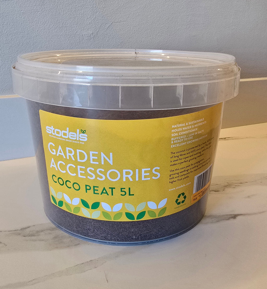 Bucket of coco peat labeled 'Garden Accessories' on a marble surface.