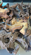 A large, intricately shaped driftwood piece with complex organic branches and hollows, displayed against a neutral light background.