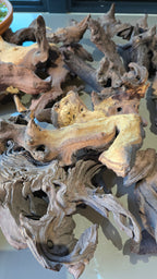 A large, intricately shaped driftwood piece with complex organic branches and hollows, displayed against a neutral light background.